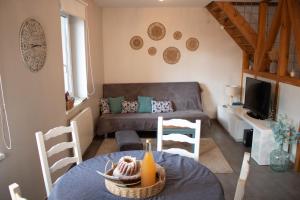 a living room with a couch and a table and chairs at Chez Rozenn et Mewen in Romanswiller
