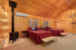 eine Blockhütte mit 2 Betten und einem Herd in der Unterkunft Oak Haven On Leech Lake in Cass Lake