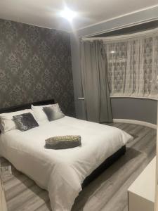 a bedroom with a large white bed and a window at Home from Home in Merton
