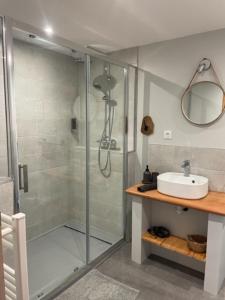 a bathroom with a glass shower and a sink at La grange du Contourés in Castanet
