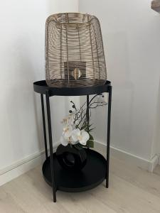 a bird cage sitting on a black stand with flowers at FMA Ferienwohnung Heubach in Heubach