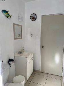 a white bathroom with a toilet and a sink at ConVal beach house in Bahía Kino