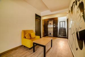 sala de estar con sofá amarillo y mesa en Townhouse 361 Sarvar Hospitality Near Ascendas Park Square Mall, en Bangalore