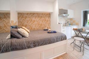 1 dormitorio con 1 cama y cocina pequeña en La Bougnate Proche des Thermes Royat/Chamalières, en Chamalières