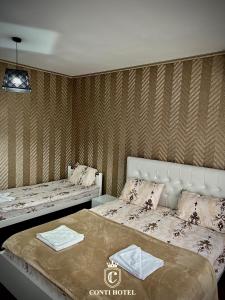 ein Schlafzimmer mit 2 Betten und Handtüchern darauf in der Unterkunft Conti Hotel & Restaurant in Gjakove
