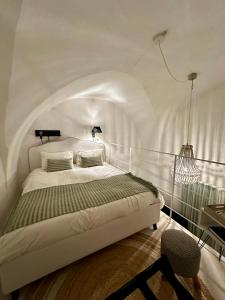 1 dormitorio con cama blanca y lámpara de araña en Dimora San Giovanni, en Nardò