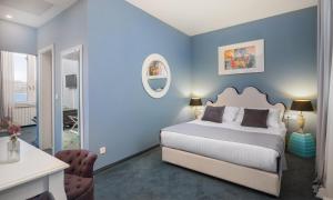 a blue bedroom with a bed and a desk at Aminess Younique Korcula Heritage Hotel in Korčula