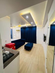 a living room with a blue couch and a table at EzyStay Boutique Suites in Lucknow