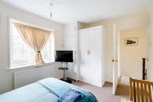 a bedroom with a bed and a window and a television at Morden House in Morden