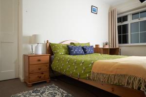 a bedroom with a bed with a green comforter at Morden House in Morden