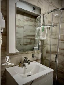 ein Bad mit einem Waschbecken und einem Spiegel in der Unterkunft Conti Hotel & Restaurant in Gjakove