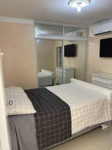 1 dormitorio con 1 cama grande y espejo en Apartamento de Lujo En San Pedro, en San Pedro de Macorís
