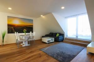 a living room with a table and a blue couch at Apartmány Mikulovské zahrady in Mikulov +37 photos