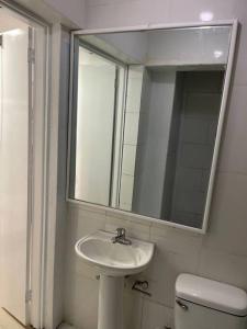 a bathroom with a sink and a mirror and a toilet at Apartamento de Lujo En San Pedro in San Pedro de Macorís