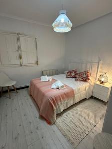 Dormitorio blanco con cama con manta rosa en Villa Sol en Avila