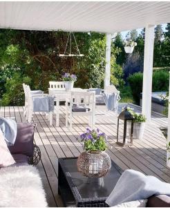 a patio with a table and chairs on a deck at Höhällets Lantliga Rum in Värnamo