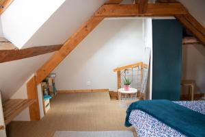 a attic bedroom with a bed and a staircase at Chez Rozenn et Mewen in Romanswiller