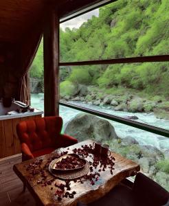 a room with a table with a view of a river at AYDER BUNGALOW - river view , Royal Bungalow Resorts in Çamlıhemşin
