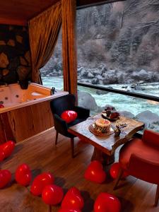a room with a tub and a table and chairs at AYDER BUNGALOW - river view , Royal Bungalow Resorts in Çamlıhemşin
