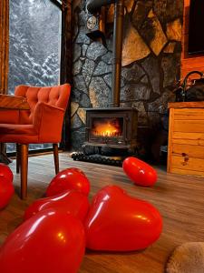 uma sala de estar com lareira e balões vermelhos em AYDER BUNGALOW - river view , Royal Bungalow Resorts em Çamlıhemşin