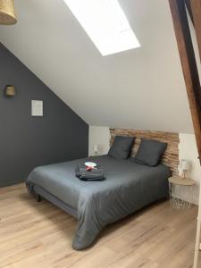 1 dormitorio con 1 cama y suelo de madera en La grange du Contourés en Castanet