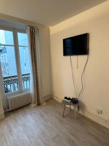 sala de estar con TV de pantalla plana en la pared en Appartement situé dans le 9ème arrondissement, à deux pas du Sacré-Coeur, en París