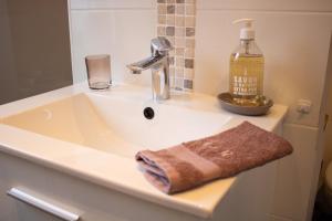 a bathroom sink with a bottle of soap and a towel at Chez Rozenn et Mewen in Romanswiller +43 photos