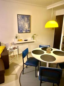 sala de estar con mesa y sillas azules en Malpica diseño, en Malpica de Bergantiños