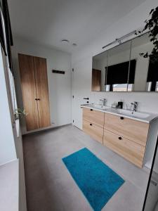 a bathroom with two sinks and a blue rug at Hotel Apartments Belgium 5 - HAB 5 in Balen +39 photos