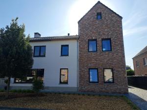 a brick and white house with black windows at Hotel Apartments Belgium 5 - HAB 5 in Balen