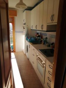 a kitchen with white cabinets and a stove top oven at Habitación privada, siéntete como en tu casa in Manzanares el Real