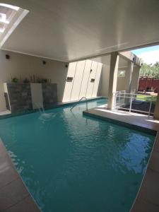 a large swimming pool in a building with water at Cabañas El Refugio in Chascomús