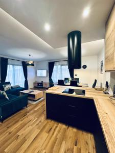 Una cocina y una sala de estar con un sofá y una mesa. en Apartament u Heleny, en Sosnówka