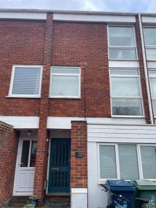 a brick apartment building with a blue door at Modern and Comfortable Flat with private parking in Oxford