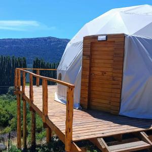 yurta con terraza de madera y puerta en Cabaña y Domos Ollagua con vista al lago en Cholila