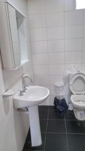 a white bathroom with a sink and a toilet at Cabañas EL SOLEADO in Zonda