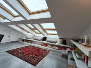 a living room with skylight ceilings and a red rug at Patio d'Azur toit terrasse haut de gamme 3 ch jacuzzi coeur de ville et plage in Saint-Raphaël