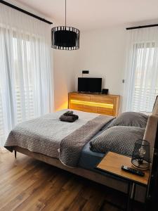 a bedroom with a bed with a table and a tv at Apartament u Heleny in Sosnówka