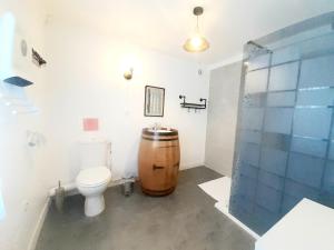 a bathroom with a toilet and a wooden barrel at Hotes'Octon in Octon