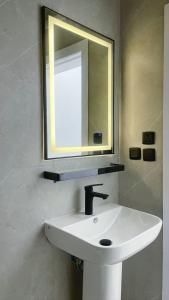 ein Badezimmer mit einem weißen Waschbecken und einem Spiegel in der Unterkunft السلطان شقق سكنية مستقلة Private independent in Medina