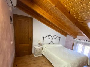 - une chambre avec un lit et un plafond en bois dans l'établissement Chalet en Librilla, à Murcie
