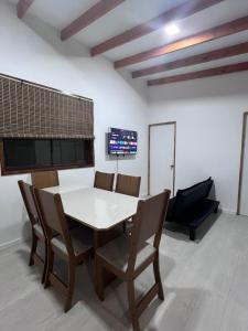 a dining room with a white table and chairs at Casa Playa Loreto in Caldera