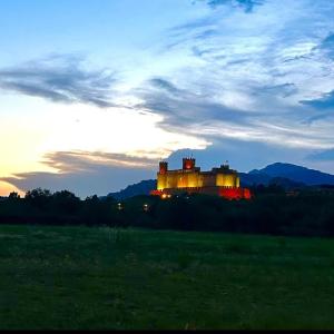 a castle is lit up at sunset in a field at Habitación privada, siéntete como en tu casa in Manzanares el Real