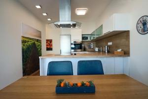 a kitchen with a table and two blue chairs at Apartmány Mikulovské zahrady in Mikulov