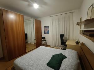 ein Schlafzimmer mit einem Bett mit einem grünen Kissen darauf in der Unterkunft Casa di Ale in Verona
