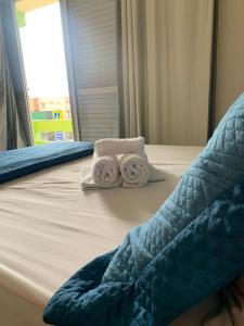a bed with two towels on top of it at Simar Hotel in Araranguá