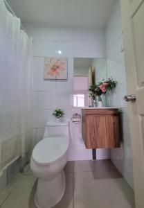 biała łazienka z toaletą i umywalką w obiekcie Hostal Chucaita Puerto Cisnes w mieście Puerto Cisnes