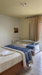 1 dormitorio con 2 camas y ventana en Simar Hotel, en Araranguá