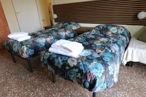 a hotel room with two beds and a couch and towels at stazione trastevere公寓 in Rome