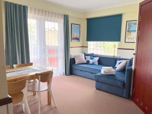 Villa Baltic Chałupy Apartament 4 في شالوبي: غرفة معيشة مع أريكة زرقاء وطاولة